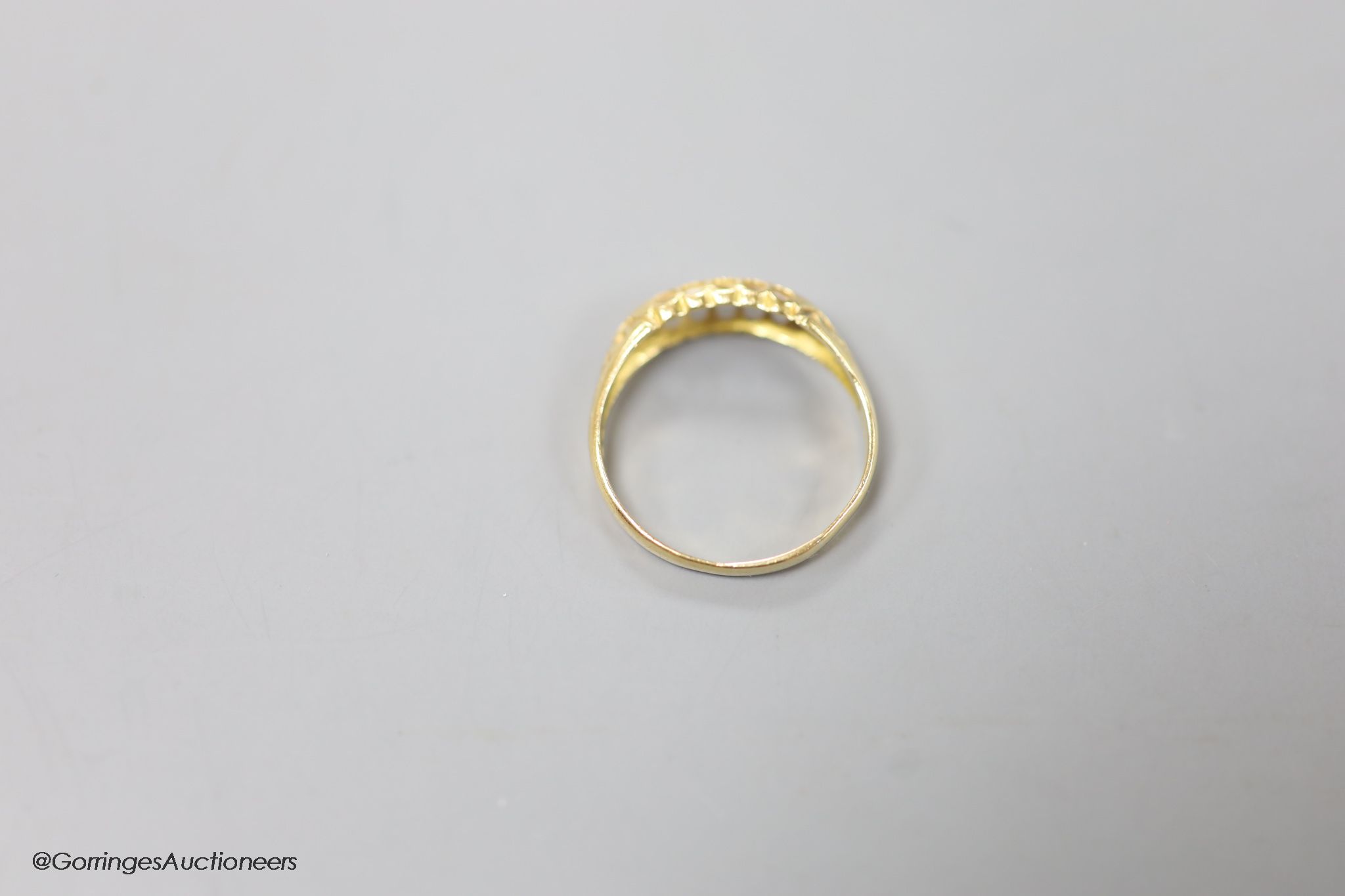 An Edwardian 18ct gold and five stone diamond chip set half hoop ring, size R, gross 2.6 grams